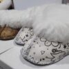 Cute sheepskin slippers for babies with heart and cupcake designs.